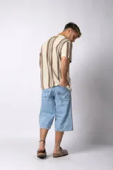 Remera de tejido de punto con diseño de rayas verticales en tonos beige y marrón, de manga corta y cuello redondo.