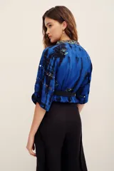 Kimono de viscosa color azul con efecto tie-dye y bordados decorativos en cuello y mangas.