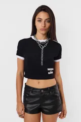 Remera corta negra de algodón tipo baby tee, con mangas cortas y detalles en blanco en cuello y mangas. Estampa frontal con la leyenda "Rocking Slaying" en blanco.