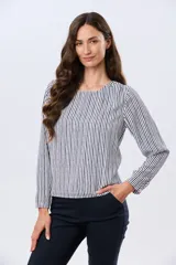 Blusa clásica de manga larga en color blanco, con cuello redondo y diseño fluido.