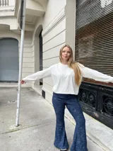 Pantalon oxford de tiro alto, confeccionado en tejido térmico de color azul con efecto desgastado. Presenta un corte ajustado en la parte superior y acampanado desde la rodilla hacia abajo.