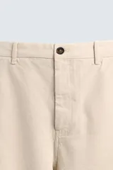 Pantalón chino de corte recto confeccionado en tejido ligero de algodón con estructura canvas. Presenta bolsillos frontales, bolsillos traseros de vivo y cierre frontal con cremallera y botón.