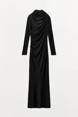 Vestido largo negro de manga larga confeccionado en mezcla de viscosa. Presenta cuello amplio multiposición y detalle de drapeado fruncido en el lateral del torso.
