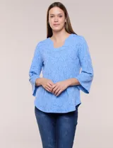 Blusa celeste de tejido texturado con relieve floral, escote redondo con muesca central, mangas tres cuartos estilo campana y ruedo curvo.