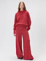 Sweater de punto jacquard con diseño texturizado, cuello alto y puños acanalados en contraste. Presenta un corte holgado y diseño inspirado en patrones naturales.