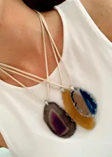 Collar con cordón de símil gamuza y dije de piedra ágata natural en forma irregular con terminaciones metálicas plateadas.