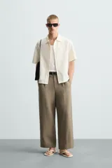 Camisa regular fit de manga corta confeccionada en tejido jacquard con estructura abierta y diseño geométrico. Presenta cuello solapa y cierre frontal con botones al tono.