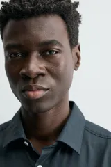 Camisa de hombre color beige claro, de corte slim fit, con cuello italiano, manga larga y cierre frontal de botonadura.