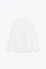 Camisa color coral confeccionada en lino 100%, de corte recto, con cuello solapa, manga larga con puños abotonados y cierre frontal con botones.