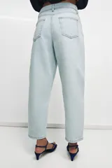 Jeans de tiro alto y silueta tapered, confeccionados en denim negro con costuras en tono contrastante. Cuenta con diseño de cinco bolsillos, trabillas para cinto y cierre frontal con cremallera y botón metálico.