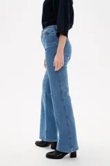 Pantalon de jean azul oscuro con corte flare, tiro alto y bolsillos frontales tipo parche.