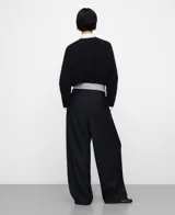 Pantalón ancho negro con pinzas en el delantero, bolsillos laterales y de vivo en la espalda, de pierna recta y tiro alto con cinturilla interior en tejido de rayas a contraste.