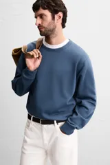 Sudadera de corte regular fit confeccionada en algodón con interior afelpado, cuello redondo y manga larga con puños y ruedo en rib.