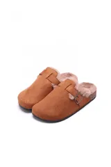 Sueco tipo zueco de gamuza color beige, con interior forrado en piel sintética suave y detalle de tira con hebilla metálica ajustable en el empeine. Suela de corcho y base de goma antideslizante.