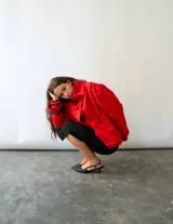 Campera de algodón color rojo, con cuello alto, cierre frontal con botones metálicos y diseño versátil de corte holgado.