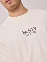 Remera de hombre color gris con efecto lavado, corte holgado y estampado con el logo de la marca Rusty en el pecho.
