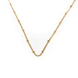 Cadena dorada de acero enchapado en oro, con eslabones finos y pequeñas bolitas espaciadas.