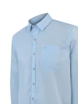 Camisa de manga larga RKF modelo Galiton, color celeste, confeccionada en algodón orgánico. Cuenta con cuello camisero, cierre frontal con botones de madera, bolsillo en el pecho con logo bordado y mangas ajustables.