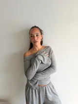 Blusa de lanilla color beige, con escote asimétrico tipo barco y mangas largas con terminación acampanada.