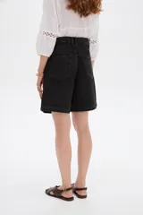 Short de jean negro de tiro alto, corte ancho, con pinzas delanteras y presillas para cinto.