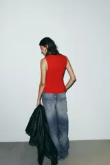 Top entallado rojo sin mangas, con cuello redondo y cierre frontal con cremallera oculta.