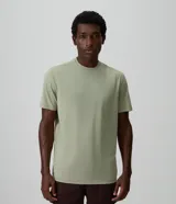 Remera deportiva de manga corta y cuello redondo en color verde claro, confeccionada en poliéster con tecnología Dry para mayor transpirabilidad. Presenta un corte cómodo y diseño liso.