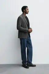 Blazer slim fit de estructura con diseño de pata de gallo, cuello con solapas de muesca, manga larga con botones en puños, bolsillos de solapa en cadera y cierre frontal con botones.