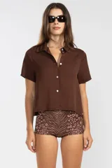 Camisa marrón de lino y tencel, de manga corta, con cuello camisero y cierre abotonado al frente.