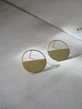 Aros colgantes plateados de diseño geométrico, formados por un aro circular con la mitad inferior sólida y texturada.