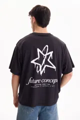 Remera de algodón negra, de manga corta y corte semi boxy, con estampa en la espalda que presenta una estrella con efecto de pintura goteando y la inscripción "future concept defining tomorrows streetstyle // culture // art".