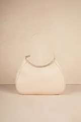 Mini bag color crema en símil cuero texturizado con asa fija.