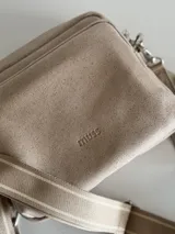 Bandolera color arena con correa de cuero y correa de tela intercambiables.