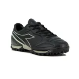 Championes de fútbol Diadora modelo Sky TF, color negro con detalles en gris oscuro. Presentan un diseño con cordones, suela con tapones para césped sintético y logo de la marca en el lateral.