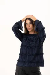 Blusa de manga larga en color azul marino, confeccionada en tejido plisado con detalles de volados horizontales a lo largo de toda la prenda.