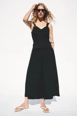 Bermuda de tiro alto de la colección Zara Woman, color negro, con bolsillos delanteros redondeados, pliegues frontales y cierre de cremallera y botón.