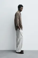 Camisa relaxed fit de algodón con estampado de cuadros en tonos marrón y beige. Cuenta con cuello solapa, manga larga con puño abotonado, bolsillo plastrón en el pecho y cierre frontal de botonadura.