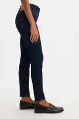Jeans skinny de tiro medio color azul oscuro, ajustados en cadera y muslos, con cierre de bragueta.