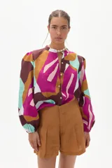 Short de lino color caramelo, de tiro alto con pinzas, bolsillos laterales y cierre frontal con gancho interno.