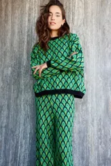 Pantalón de punto con spandex, estampado con diseño geométrico en tonos verdes y negros.