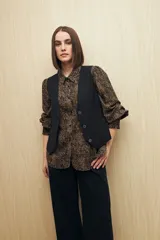 Camisa blanca con estampado lineal irregular en negro, de calce relajado, cuello clásico, abotonadura frontal y mangas largas con puños elastizados.