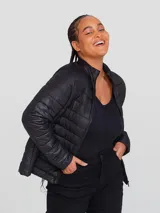 Campera puffer color crudo, con cuello alto y cierre frontal. Tiene bolsillos laterales y diseño matelassé horizontal.