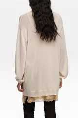 Jersey de punto de corte recto en mezcla de algodón, con escote en V pronunciado y mangas largas con puños acanalados.