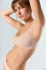 Top de estilo deportivo confeccionado en tejido seamless, con breteles finos y escote redondeado. Presenta un diseño minimalista y ajustado con el logo de la marca estampado en el bajo busto.