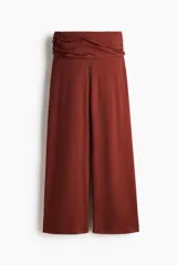 Pantalón en punto fino suave con piernas amplias. Cintura ancha con costuras laterales fruncidas para crear un efecto drapeado, color marrón rojizo.
