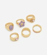 Kit de seis anillos dorados de metal con acabado esmaltado y apliques de resina y strass. Incluye piezas con formas variadas como estrella y corazones.