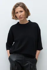 Sweater de punto color ciruela, con cuello redondo, mangas 3/4 y corte holgado.