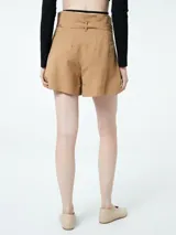 Short color marrón claro de lino y viscosa, con cintura alta, pinzas delanteras y cinturón de lazo.