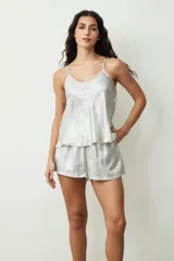 Conjunto de pijama plateado brillante, compuesto por un top de tirantes con escote en V y shorts sueltos.