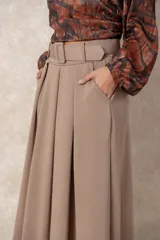 Pollera midi de corte acampanado y tiro alto, con diseño plisado en la cintura y bolsillos laterales. Confeccionada en tela de textura suave color beige.