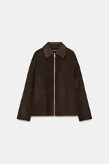 Chaqueta de corte recto confeccionada en hilatura con lana, en color marrón oscuro. Presenta cuello clásico en tejido efecto piel de ante, cierre frontal con cremallera metálica y manga larga.